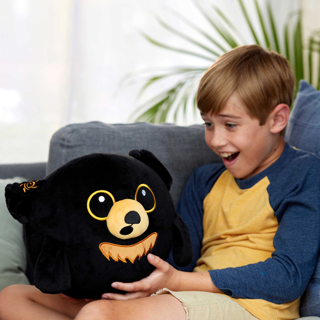 boy holding new doomlings plushie with excitement