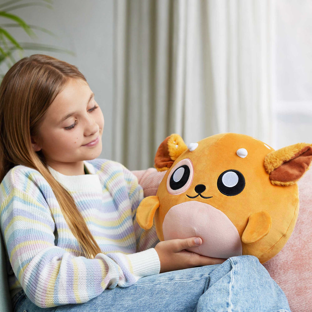 girl holding doomlings fawn plush and smiling